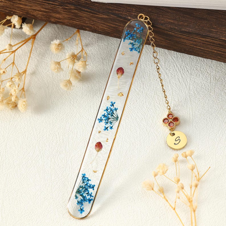 Handgefertigter Harz-Lesezeichen mit getrockneten blauen Blüten, roten Beeren und Goldfolie, mit Anhänger und Geburtsstein